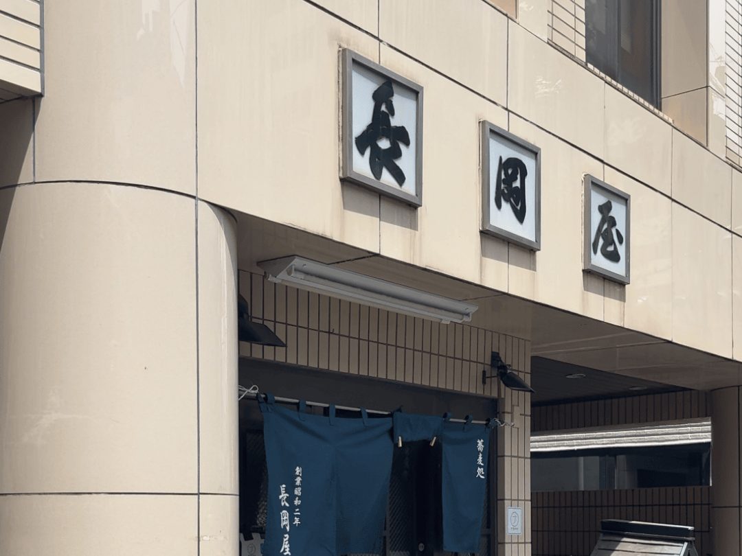 長岡屋の看板と紺の暖簾の入口